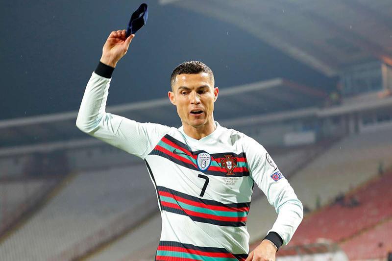 Cristiano Ronaldo terlihat membuka dan akan melemparkan ban kapten Timnas Portugal setelah marah karena golnya diabaikan oleh wasit saat melawan Serbia dalam Pra Piala Dunia 2022 di Beograd. (REUTERS/GOAL)